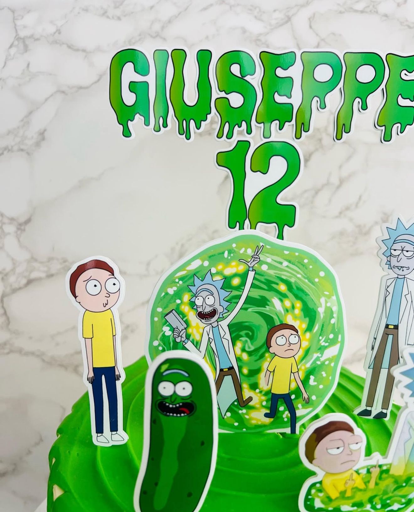 Cake with cartoon characters and 'Giuseppe 12' text on a marble background